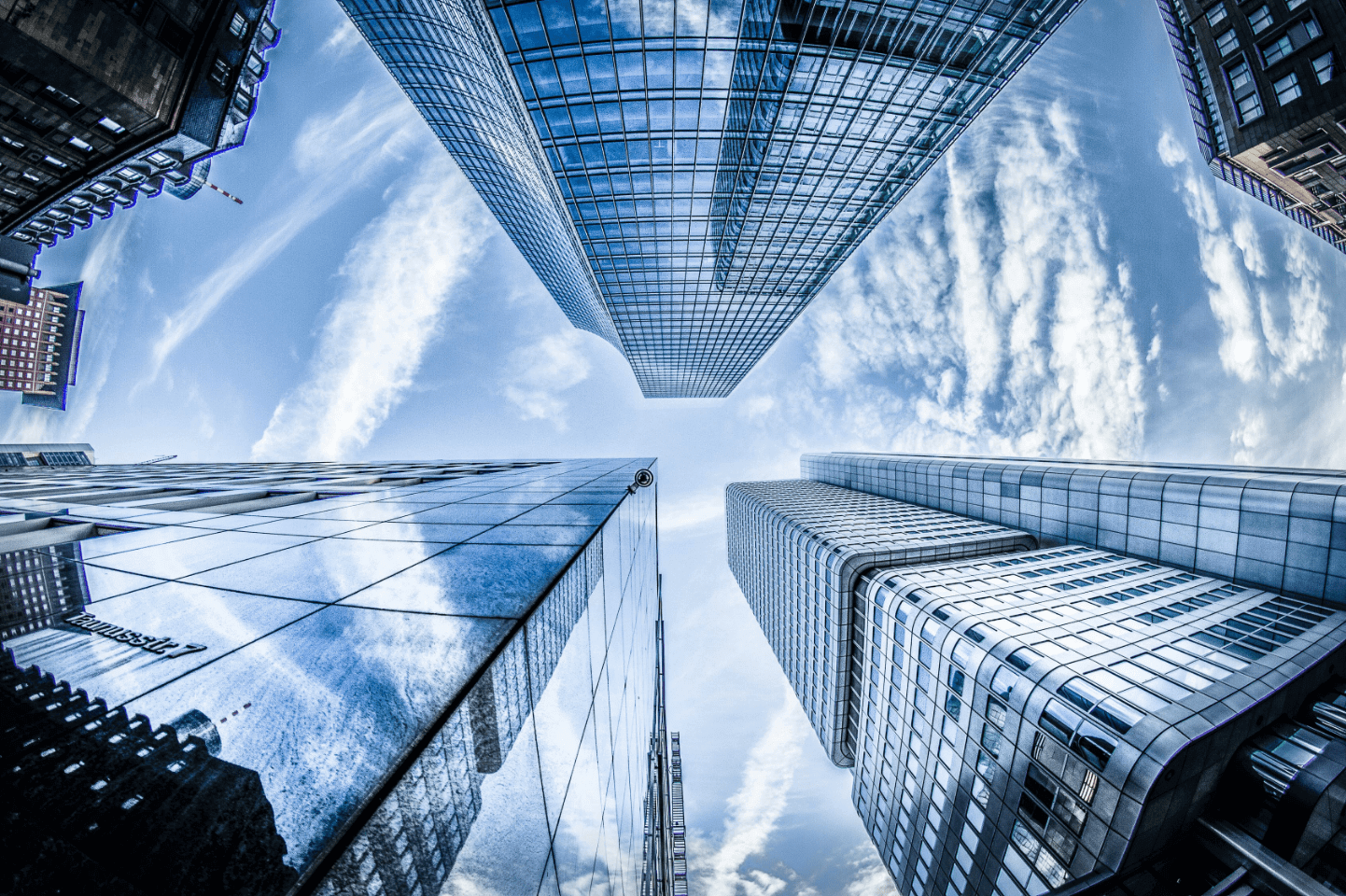 Image of a downtown area looking straight up between the highrises.